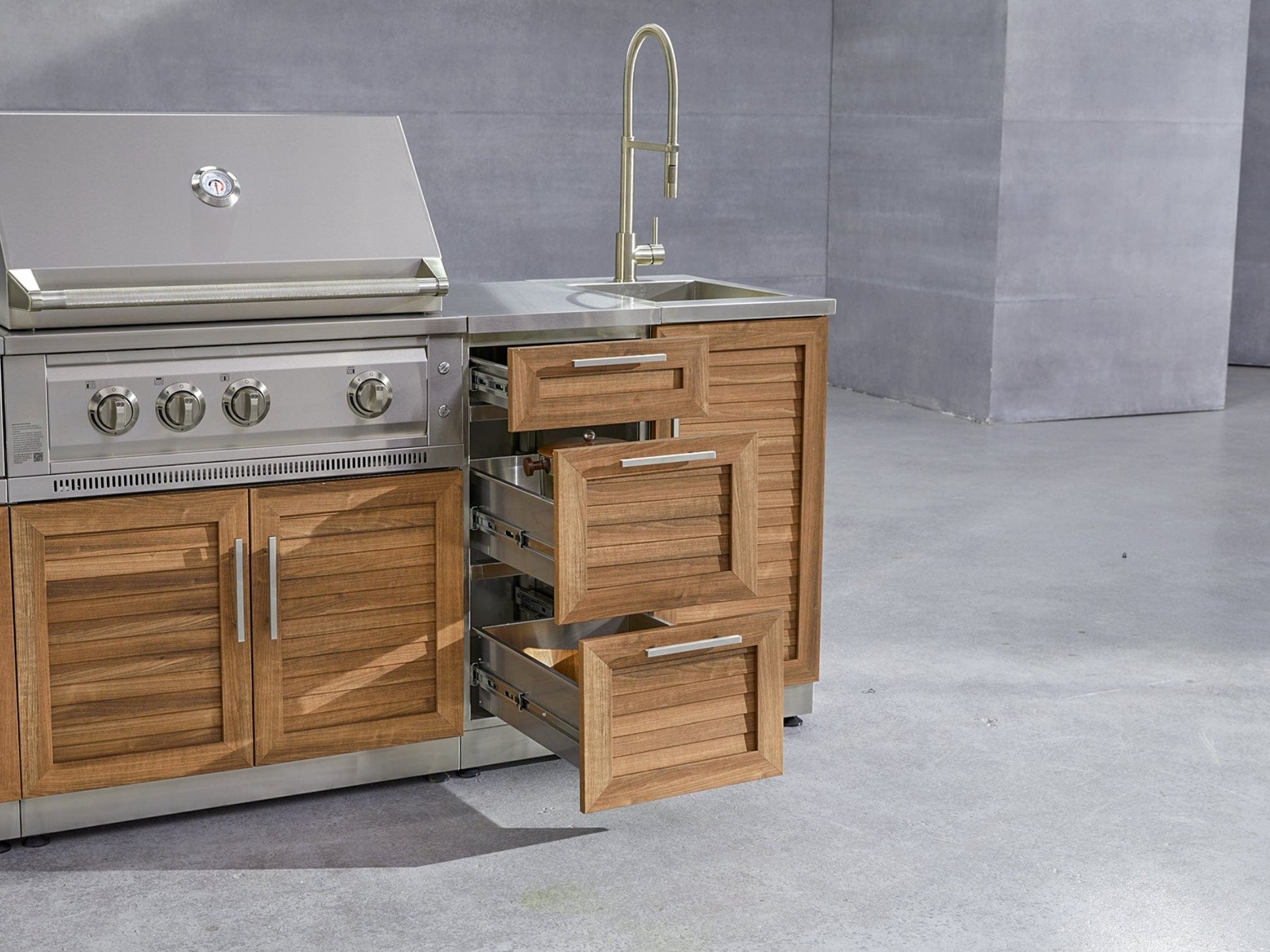 Modern outdoor kitchen with grill, sink, and open drawers showcases sleek outdoor cabinets and premium features.