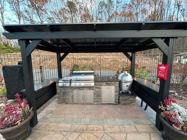 Custom outdoor kitchen island with stone finish and built-in grill