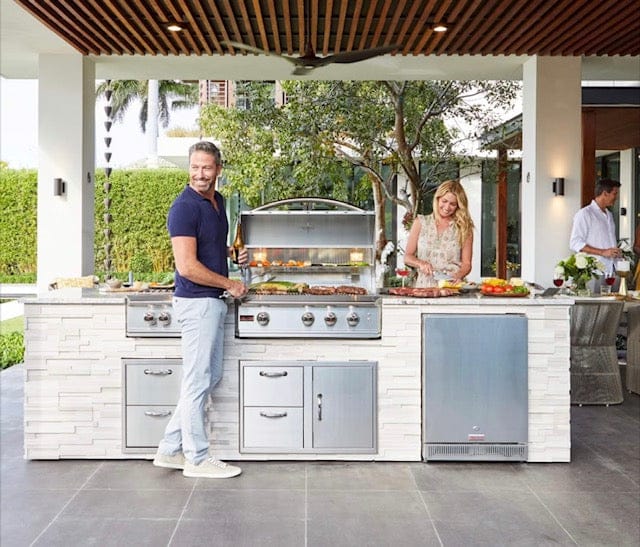 Custom outdoor kitchen island with stone exterior and stainless steel grill