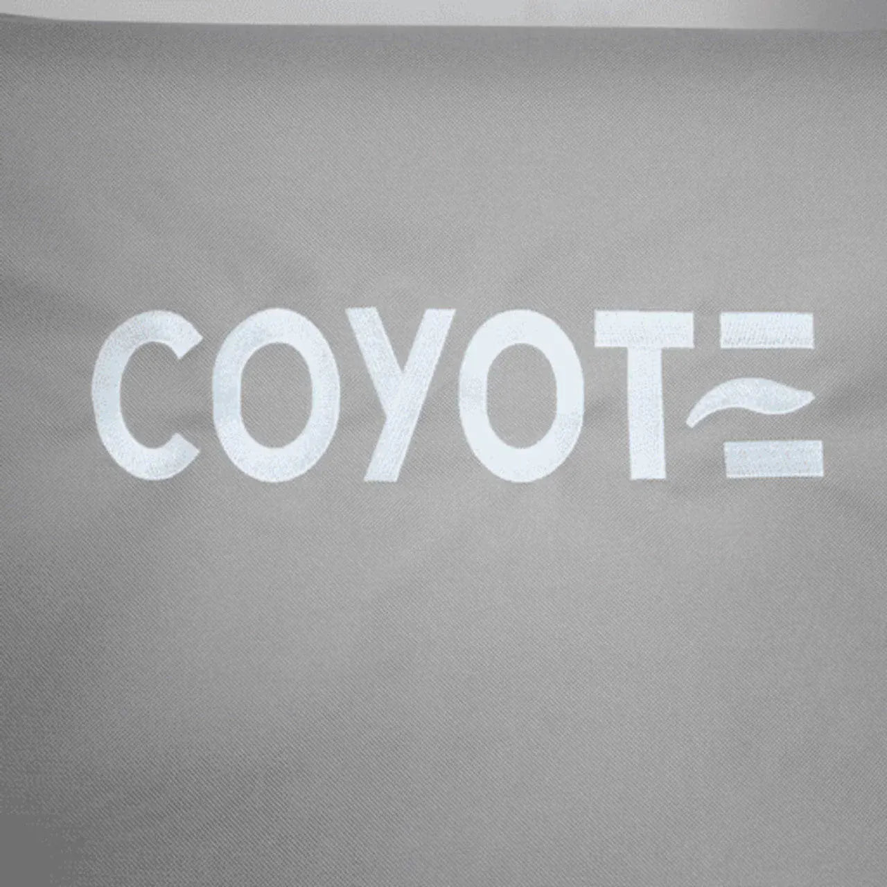 Gray fabric with white COYOTE lettering and wavy line, durable cover for outdoor grills.