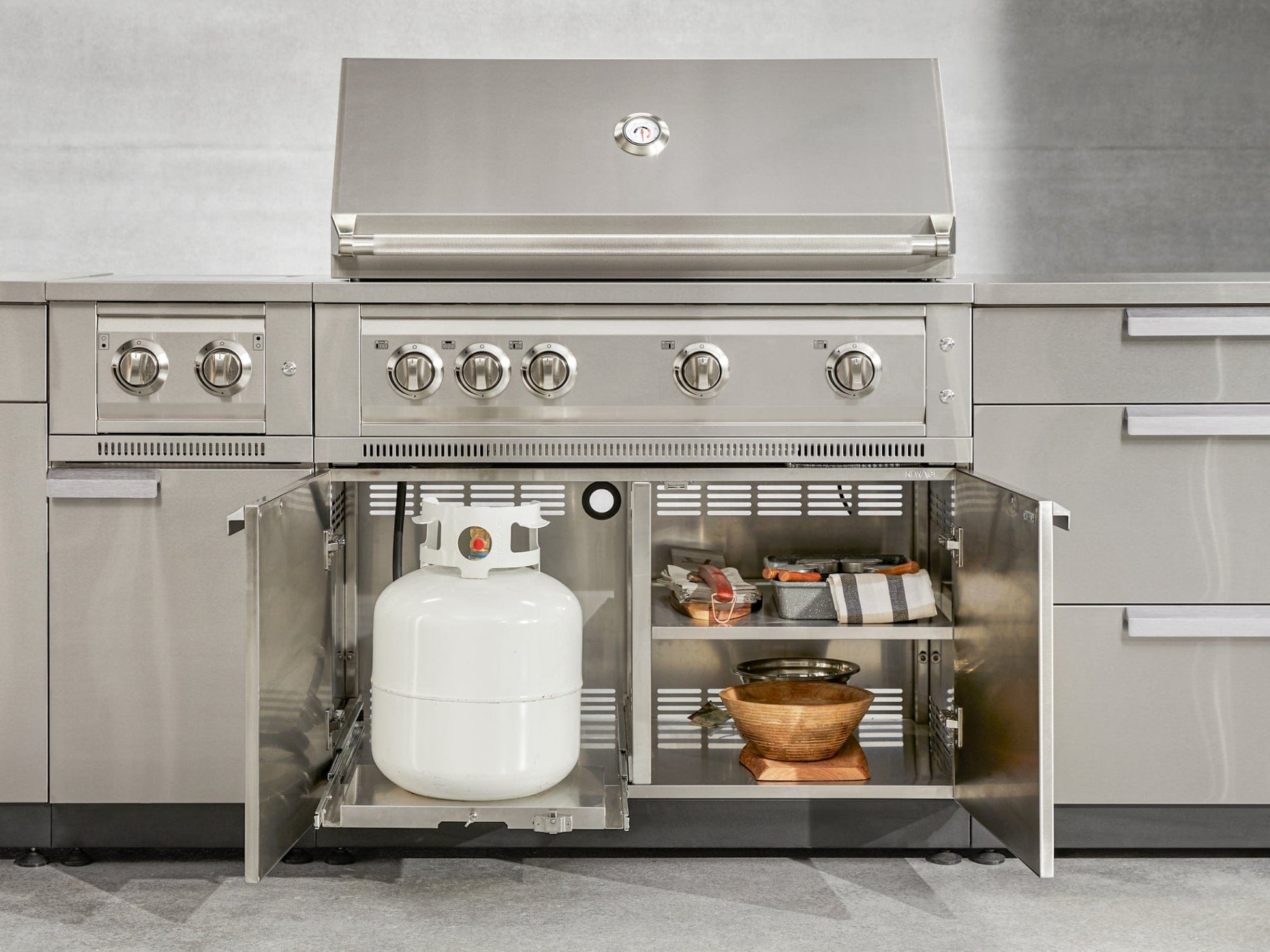 Premium outdoor grill with stainless steel cabinets, open storage, and accessory space for luxury outdoor kitchens.