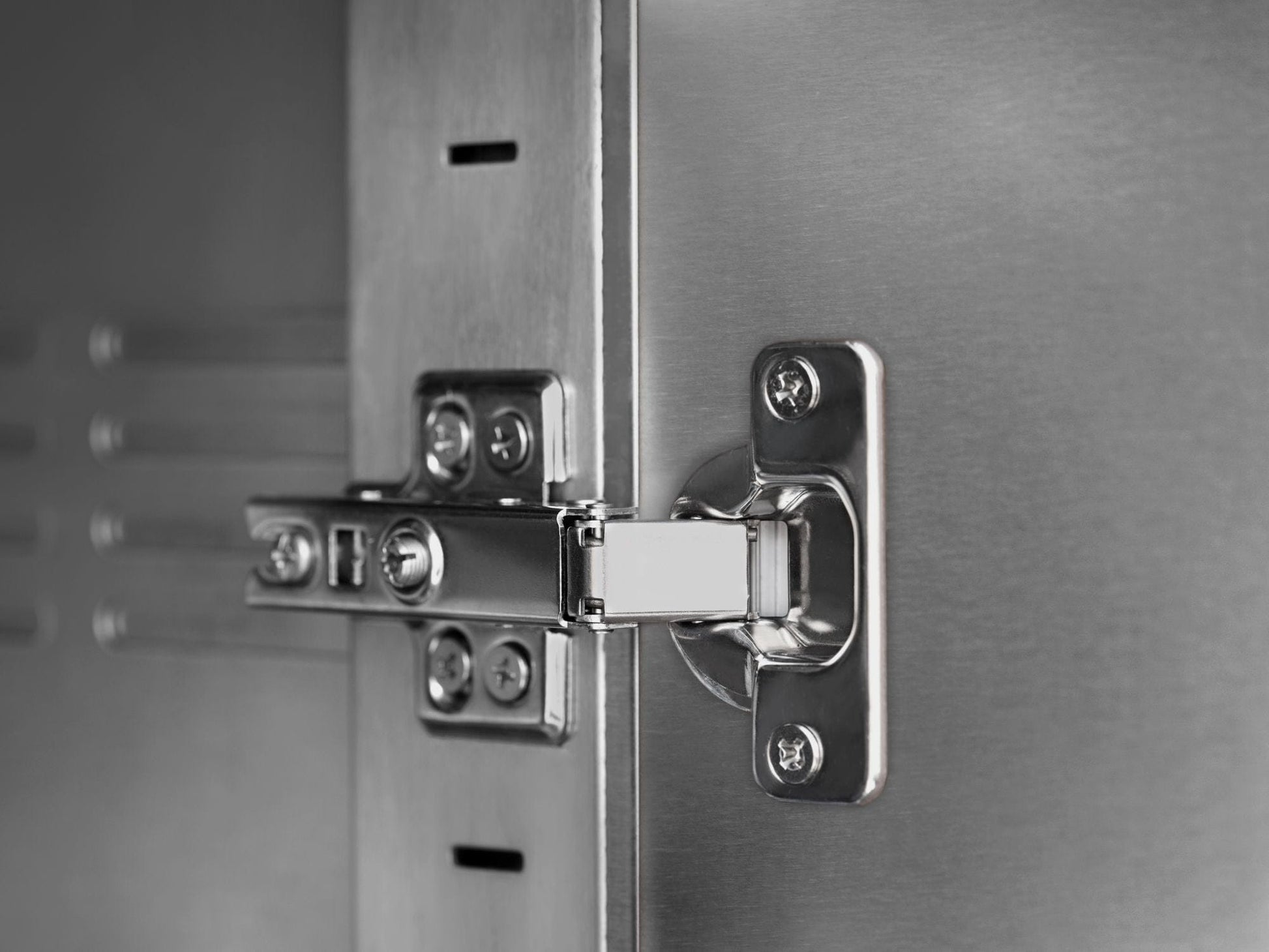 Detail of a stainless steel hinge on premium outdoor kitchen cabinets with a sleek, durable finish.