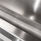 Detail of a knurled metal bar with crisscross design, shown on sleek stainless steel outdoor kitchen cabinetry.