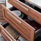 Open kitchen drawers display neatly organized plates, bowls, and placemats for premium outdoor kitchens with sink access.
