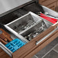 Open NewAge stainless steel kitchen drawer with organized silverware, knives, and blue cutlery tray for outdoor kitchens.