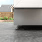 Sleek outdoor kitchen with gray finish and round base beside NewAge cabinets, featuring premium metal accents.