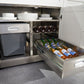 Open NewAge stainless steel cabinet with plates, trash bin, wine bottles, and drawer with bottled drinks.
