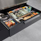 Premium modular outdoor kitchen drawer open, showing organized spices, utensils, and containers in stainless finish.